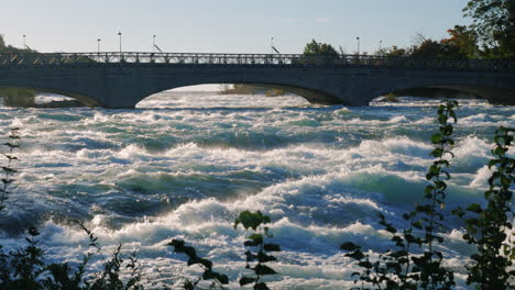 niagara falls and the bridge across the niagara river where tourists walk