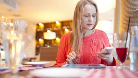 woman in cafe with touchpad and phone