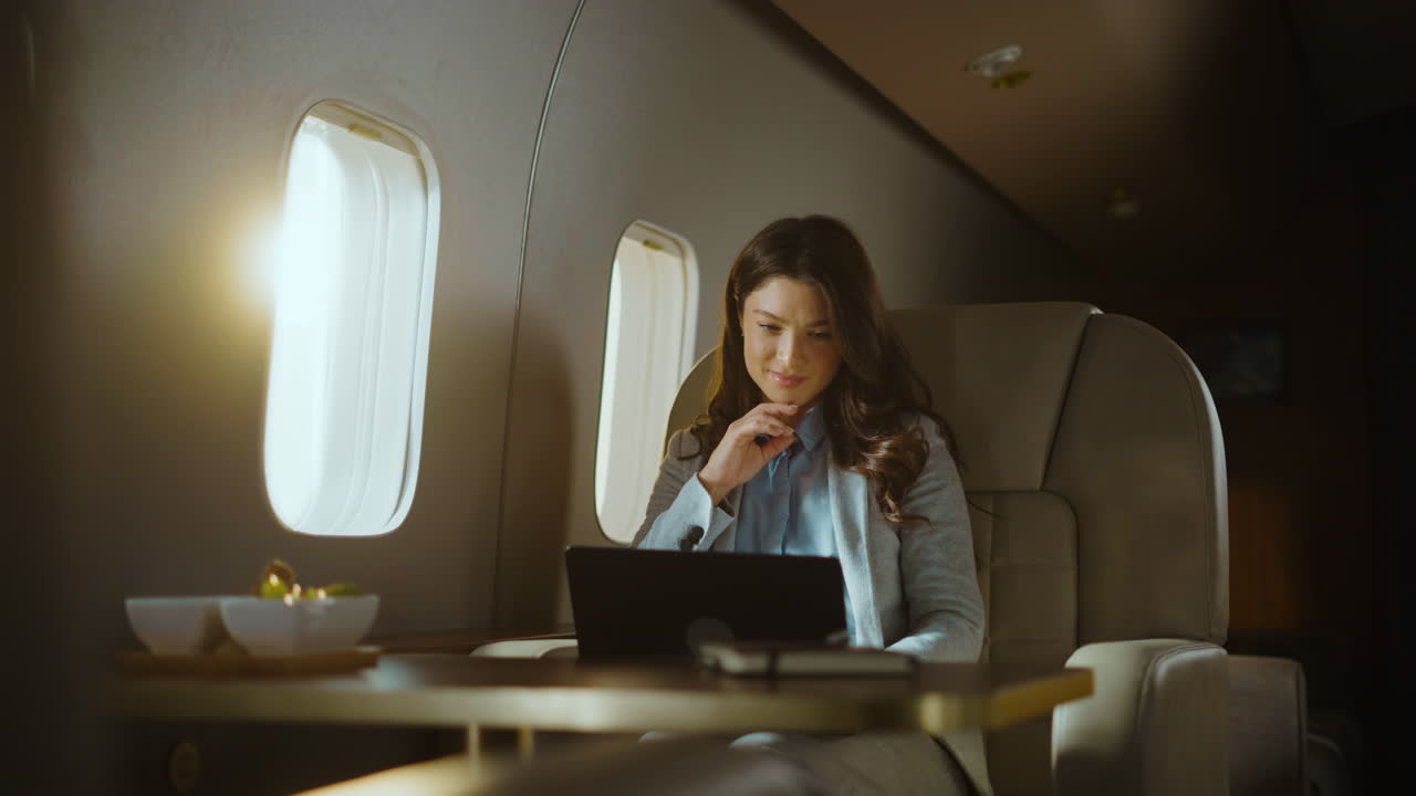 Woman working on laptop during private jet flight
