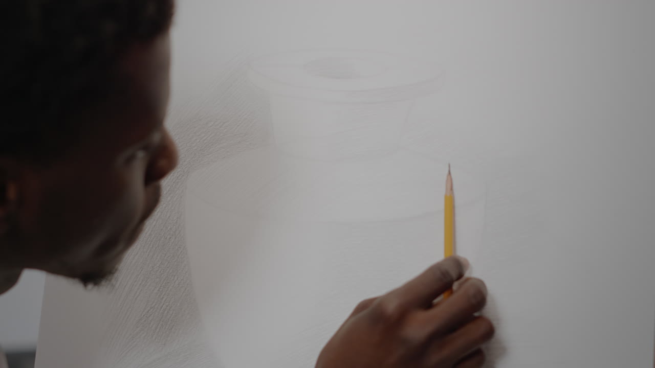 Close up of drawing of vase with black hand holding pencil