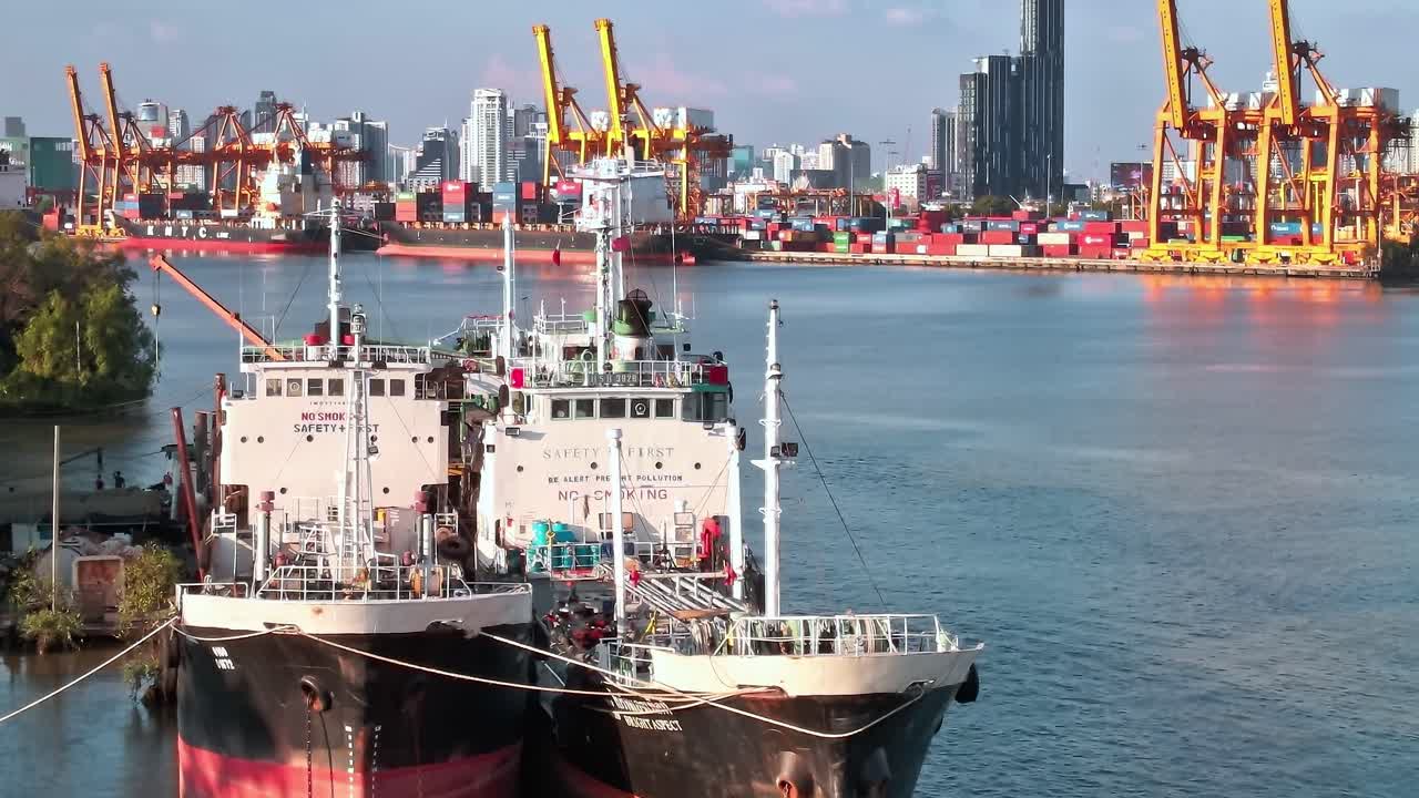View of boats and busy port area in Bangkok with city skyline