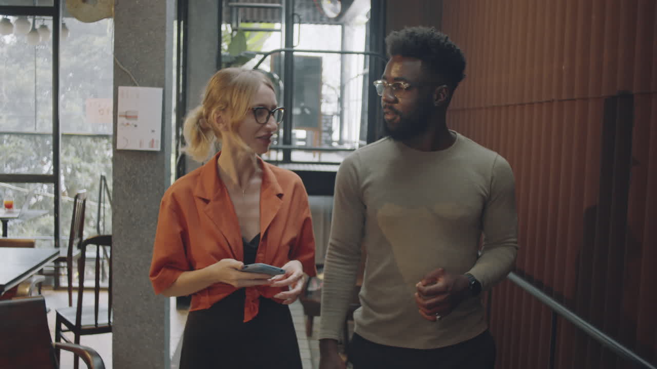 Two people talking and walking indoors