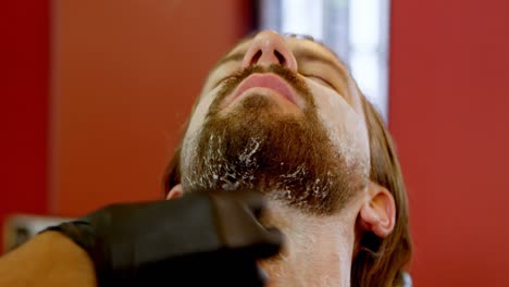 peluquero aplicando crema de afeitar en el salón de belleza 4k