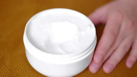 hand of woman taking white color cream, close up