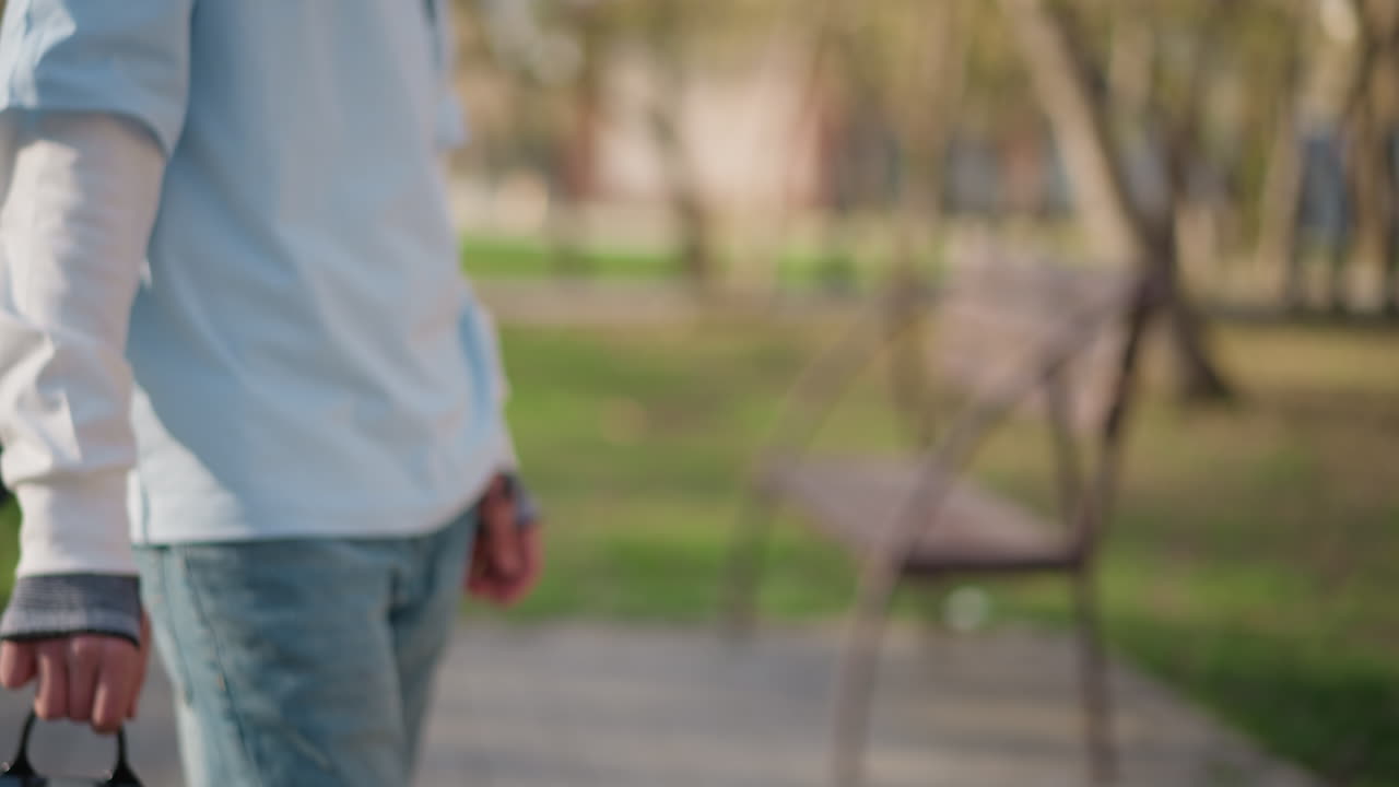 공원에서 반짝이는 백팩을 멘 사람, 조용한 공원 벤치 근처에서 검은색 가방을 들고 휴식을 취하는 남성, 나무와 은은한 조명이 있는 조용한 공원 근처에서 세련된 검은색 백팩을 들고 있는 남자