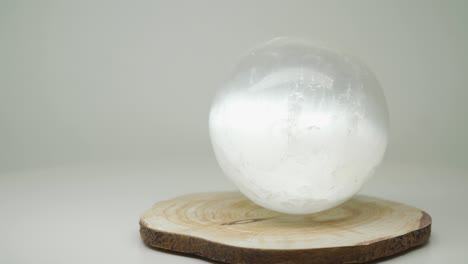 the bright round crystal ball on a wood craft on top of the turntable - close up shot