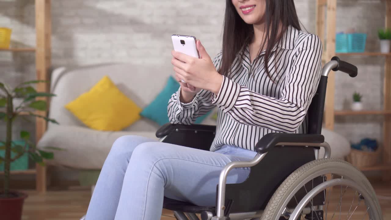 young pretty asian disabled woman in a wheelchair uses a smartphone