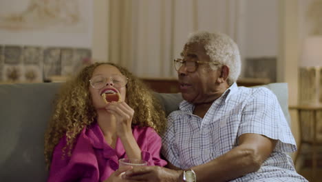 ragazza carina e nonno che fanno uno spuntino a tarda notte insieme