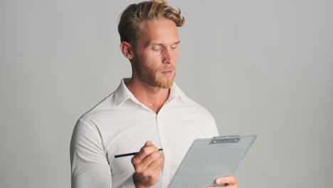 businessman holding clipboard and writing