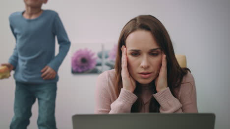 Madre-Estresada-Mirando-Una-Computadora-Portátil-En-Casa.-Mujer-Cálmate-Hijo