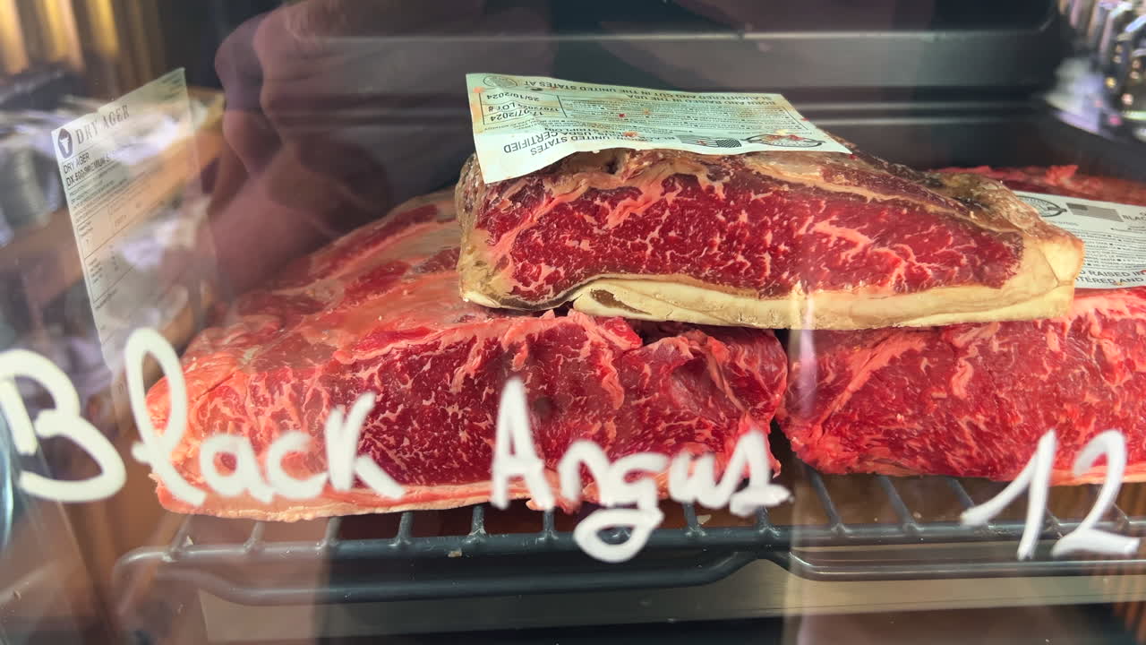 Black Angus beef in a Dry Ager machine fridge for sale in Spain, high quality meat, premium steak in a store, fresh raw meat at a butcher shop, 4K shot