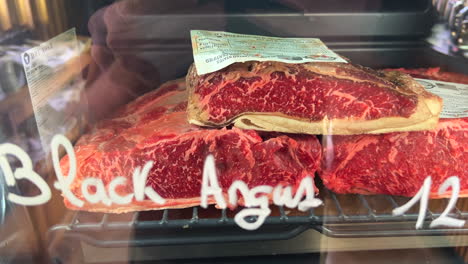 black angus beef in a dry ager machine fridge for sale in spain, high quality meat, premium steak in a store, fresh raw meat at a butcher shop, 4k shot