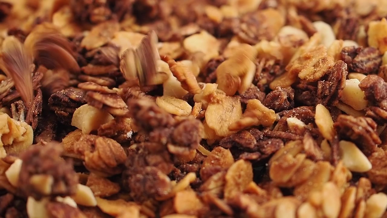 Primo piano di granola e frutta secca che cadono.