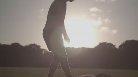 hombre estirando las piernas antes de correr mientras el sol de la tarde lo perfila - sin calificar