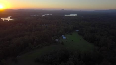 Aerial-view-of-Sunshine-Coast-landscape-with-forests,-lakes,-mountains-and-beautiful-pink-sunset