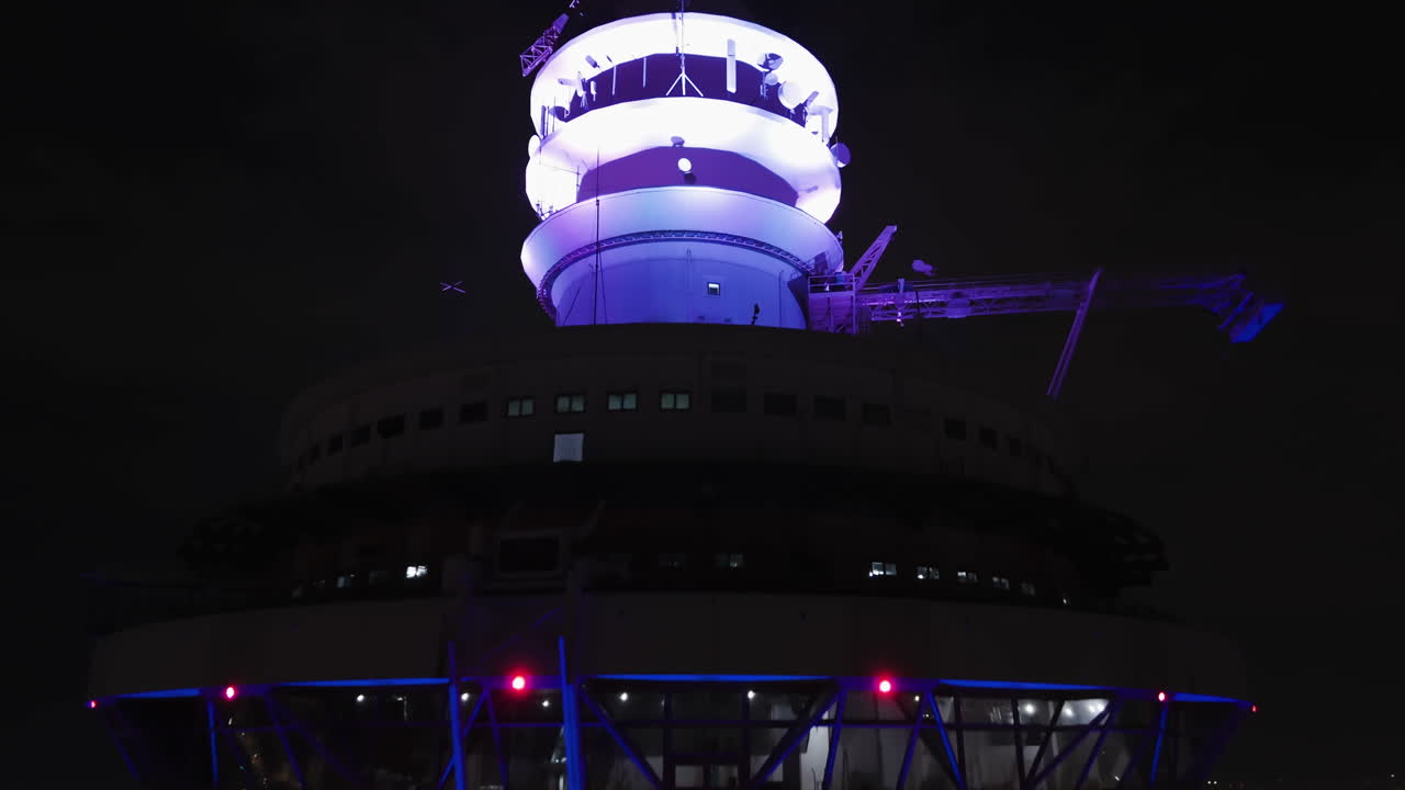 Aerial view rising around the illuminated Kuala Lumpur tower, night in Malaysia