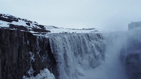 waterfall on snowy cliff in winter