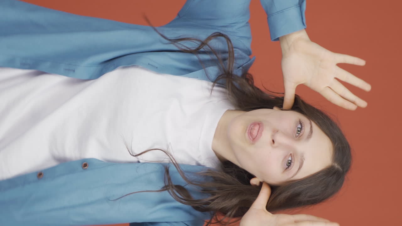 젊은 여성의 수직 비디오는 재미있는 방식으로 춤을 추고 있습니다.