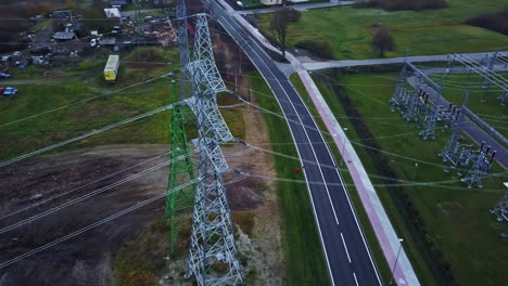 Cars-Driving-On-Asphalt-Road-Along-The-Transmission-Towers-And-Electrical-Substation