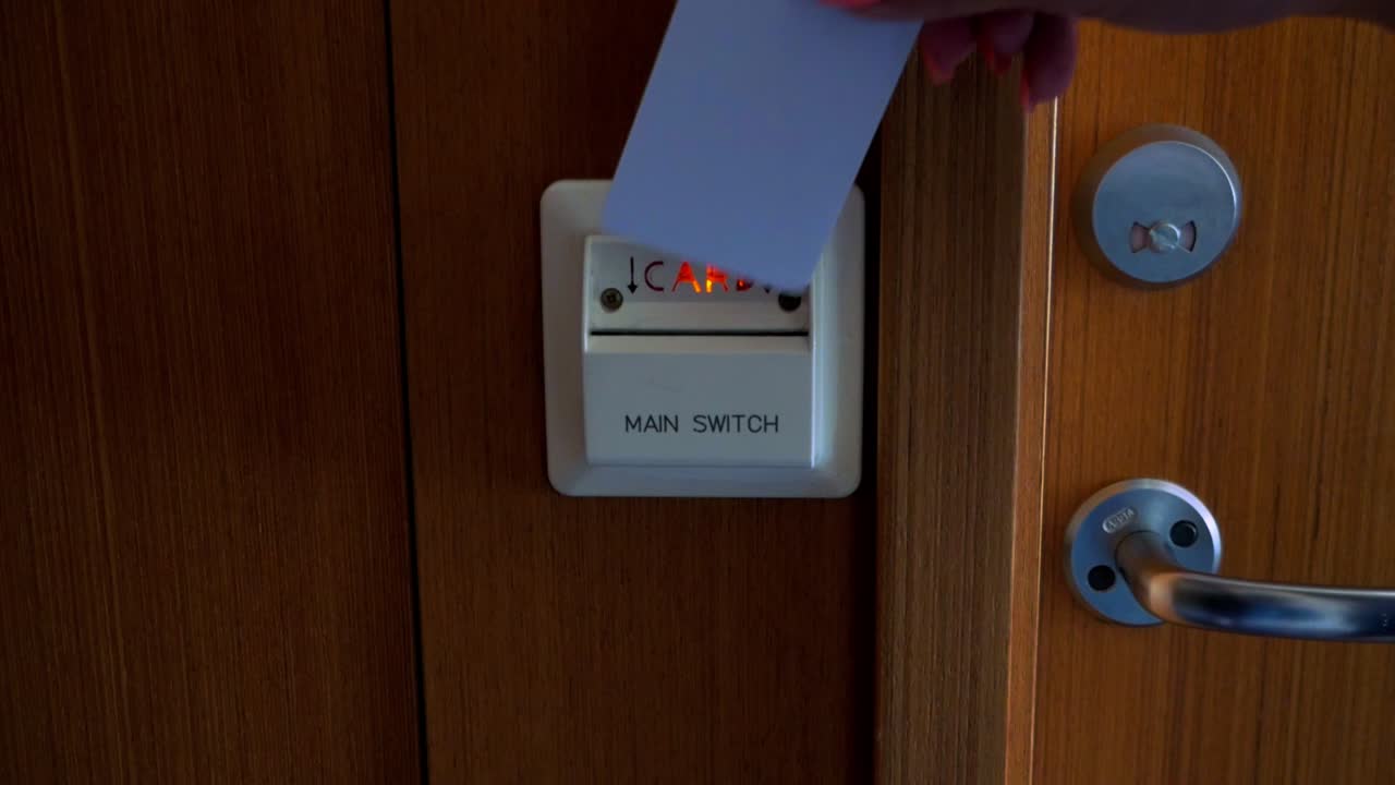 Slow motion shot of putting a hotel card into hotel room electricity activation