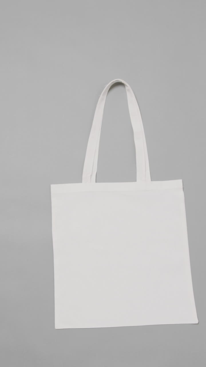 Vertical video of white bag on white background, copy space, slow motion