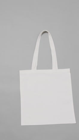 vertical video of white bag on white background, copy space, slow motion