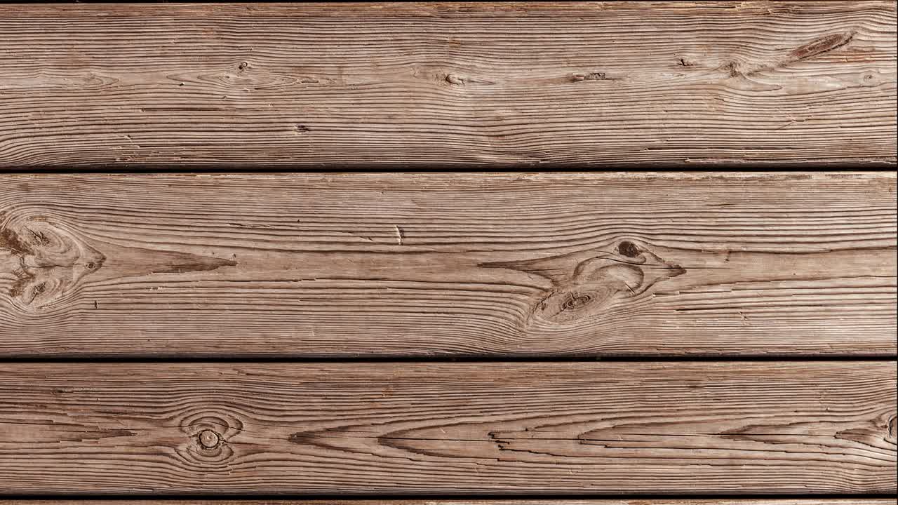 movimiento de bucle sin costuras. fondo de viejas tablas de madera lisas. envejecimiento natural al aire libre bajo el sol y la lluvia. video orientado verticalmente.