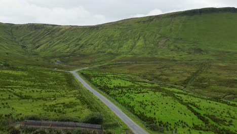 Drohnenaufnahme-Eines-Autos,-Das-Die-Straße-Entlang-Fährt,-Von-Glenniff-Horseshoe