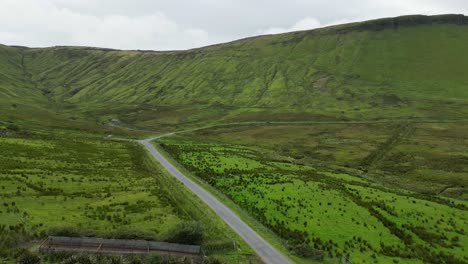 drone shot of a car driving along the road by glenniff horseshoe