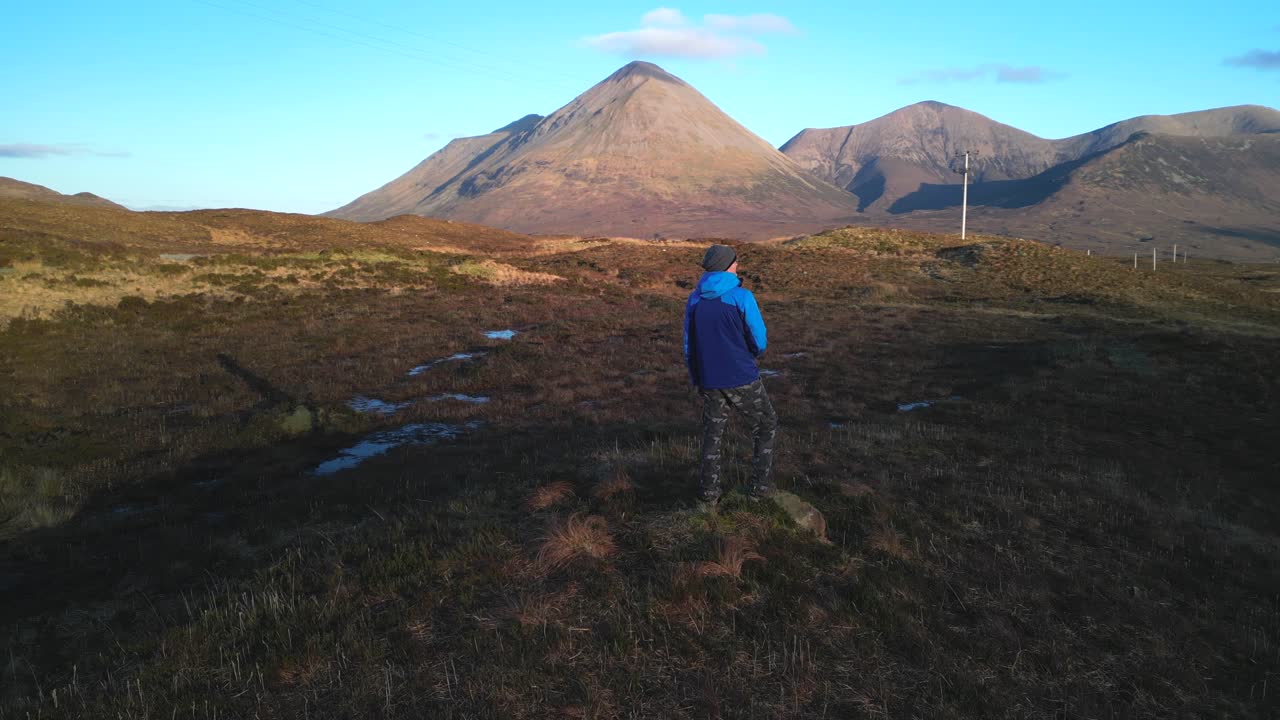excursionista y cacerola lenta a través de las montañas red cuillin al amanecer en la isla de skye, escocia