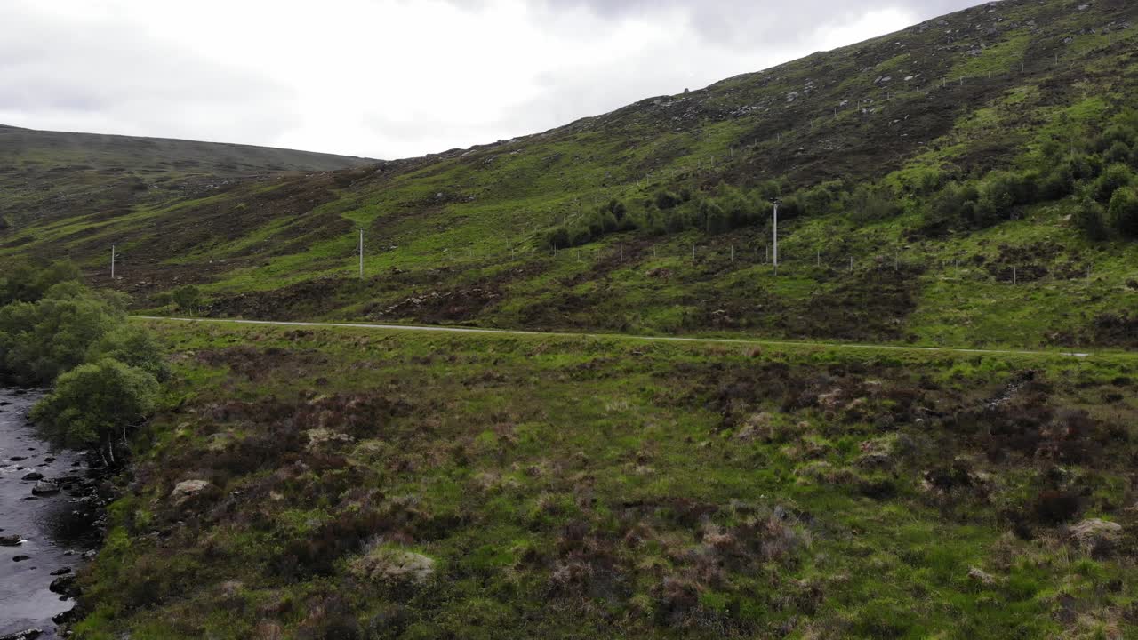 Low Drone footage, sweeping pan right at A838 Lairg. Alongside Merkland Lodge. Scottish Highlands. Ungraded. 58.218945, -4.726809. June 2019