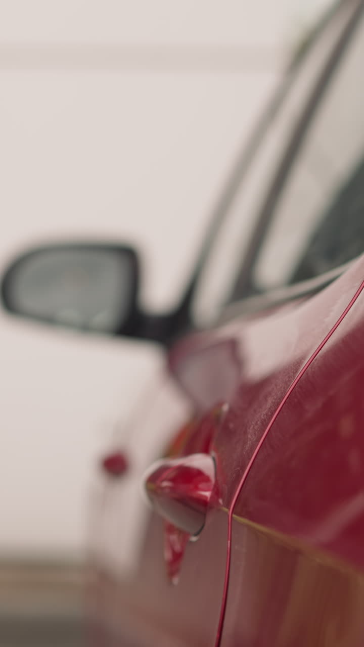 Elegant woman with leather handbag closes door of red automobile walking away. Long-haired lady in green suit arrived at office building closeup slow motion