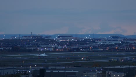 huge plane taking off from toronto pearson airport during blue hour