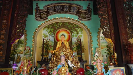 tilt up view of a colorful buddhist altar at marble mountain, da nang, vietnam with multiple buddha figures