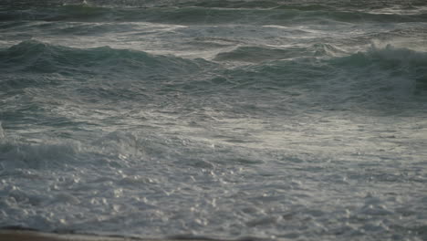 Zooming-out-of-South-African-waves-crashing-on-beach-at-sunrise