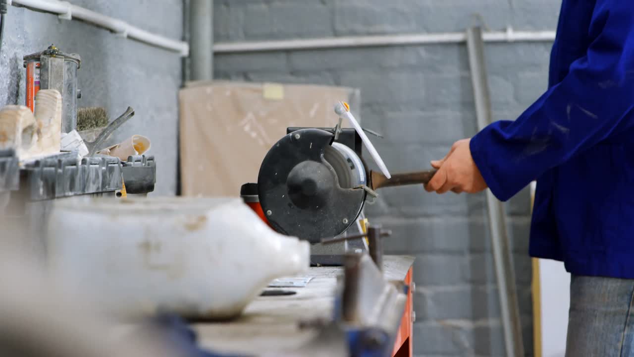 mecánico que usa una máquina de afilar en el garaje 4k