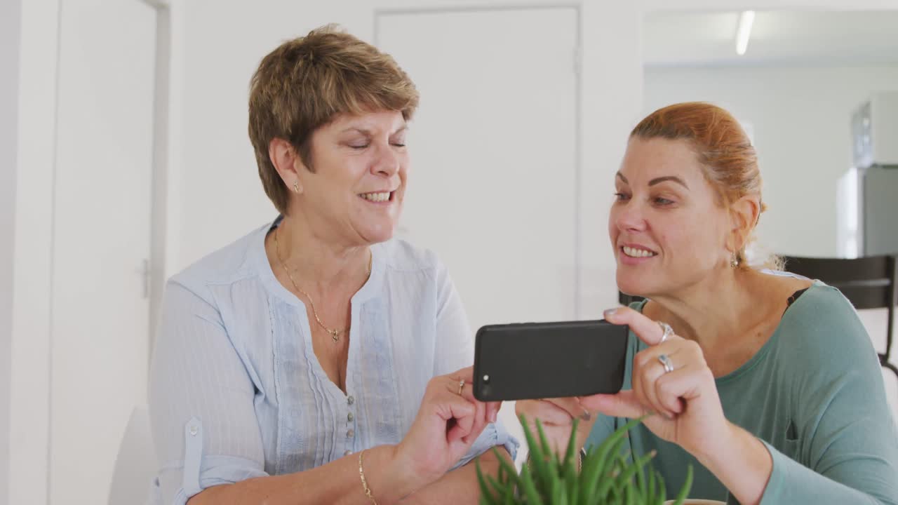 카우카시안 시니어 여성 친구들이 함께 테이블에 앉아서 무도회 춤을 추기 전에 소통하고 있습니다.