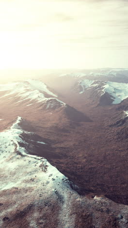 aerial view of a mountain range with snow-covered peaks