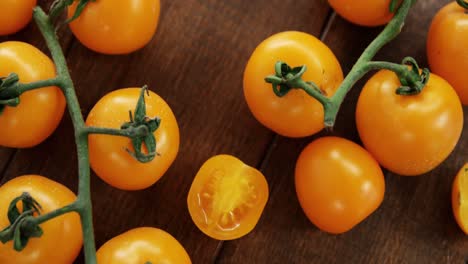 tomates de cerezas amarillas y tomates amarillos cortados en dados sobre un fondo de mesa de madera