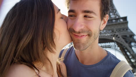 couple kissing in front of the eiffel tower