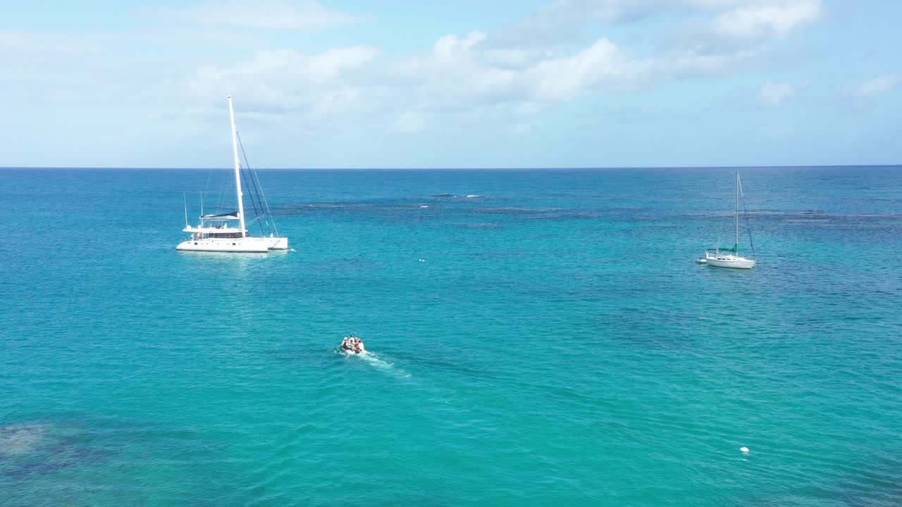 lancha motora que transporta personas a un catamarán para un viaje en el mar caribe durante un día soleado con agua azul y cielo - república dominicana, playa punta popy