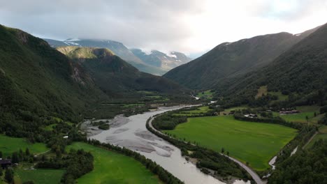 river passing through narrow mountains and beautiful green scenery in norway drone shot