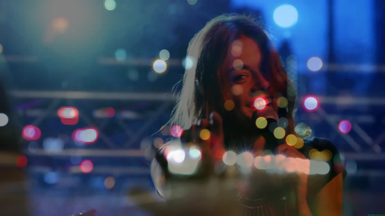Silhouette singer stepping forward, taking mic and singing and pointing at camera with city lights