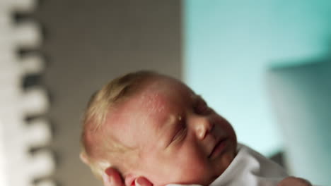 lovely cute newborn sleeping sweetly on mom's hand. close up. waving a baby to calm him down.