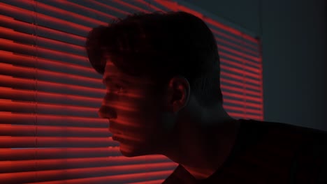 young man looking out of a window at night
