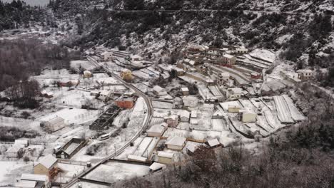 AERIAL---Village-of-Virpazar-in-snowy-winter,-mountains,-Bar,-Montenegro,-truck-right