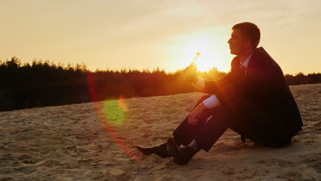 A-businessman-drinks-alcohol-and-sits-on-the-sand-1