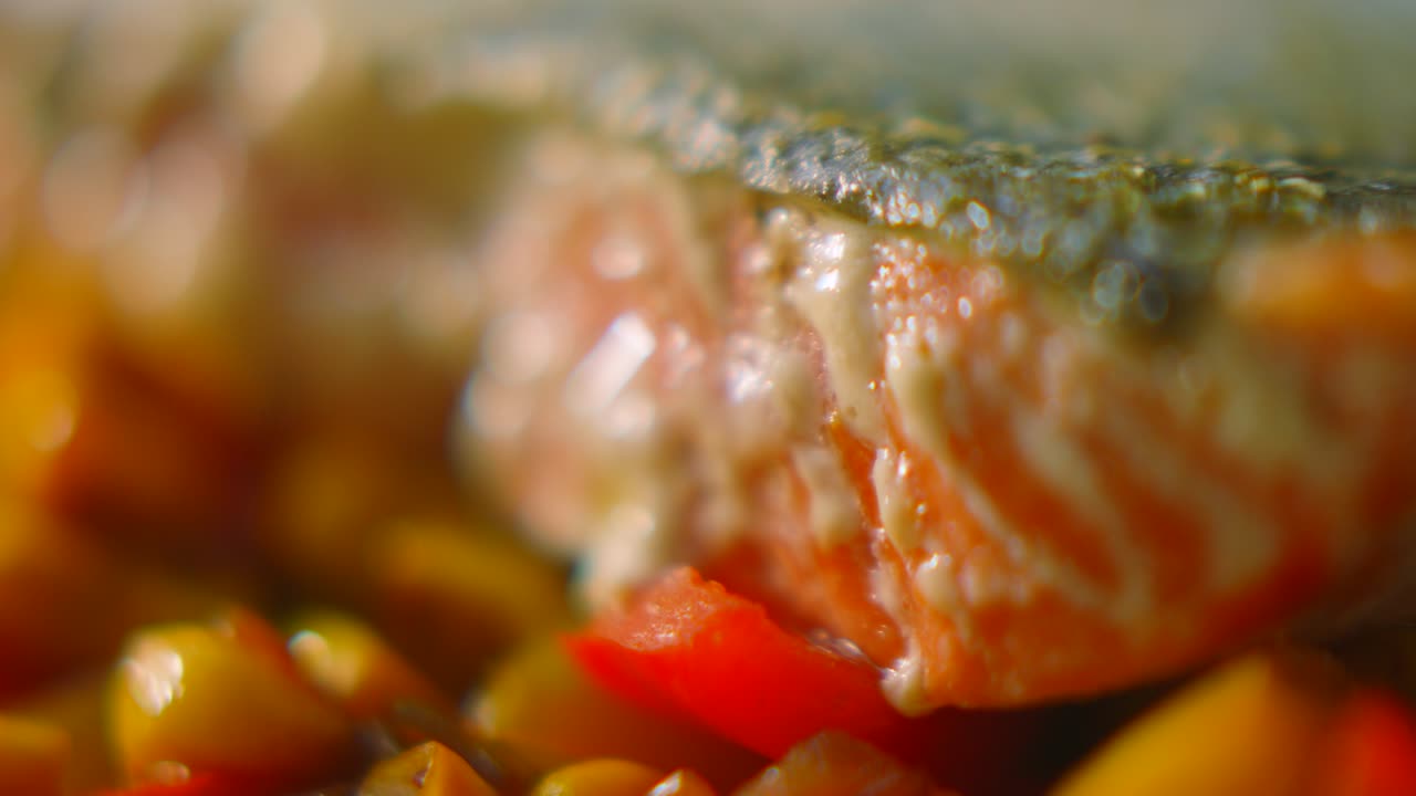 Slow Moving Macro Shot Across Small Cut Peppers and Sweetcorn with Salmon Fillet Resting on Top with Crsipy Skin and High Level of Detail. Seafood Healthy Omega-3 Meal