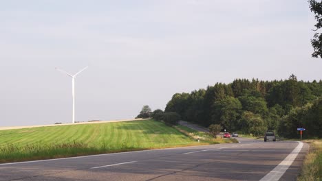 cars driving road, windmill in background, fast motion or timelapse, low angle static camera