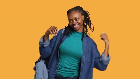 Thrilled-young-girl-doing-happy-dance,-feeling-jolly,-studio-background.